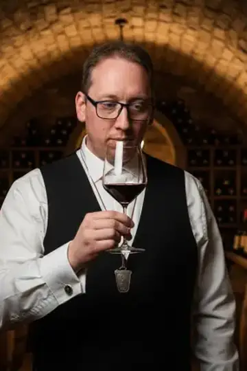 KI-Look Sommelier: Als Sommelier im Gewölbekeller beim Verkosten.